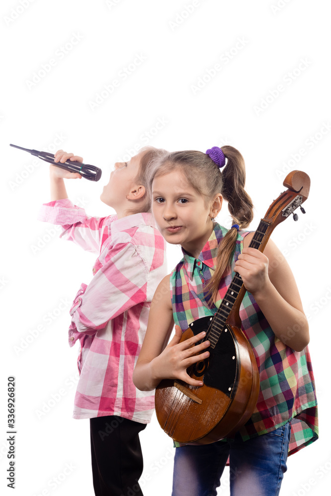 Two cute little girls posing with a microphone and domra. Two cute little girls posing with a microphone and domra.