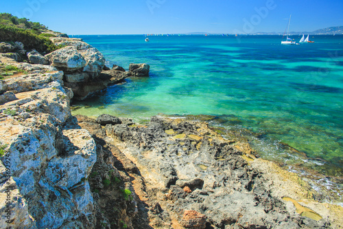 Fototapeta Naklejka Na Ścianę i Meble -  summer weather in Spain. view over beautiful coast with sailing boats in the south of Mallorca, Spain