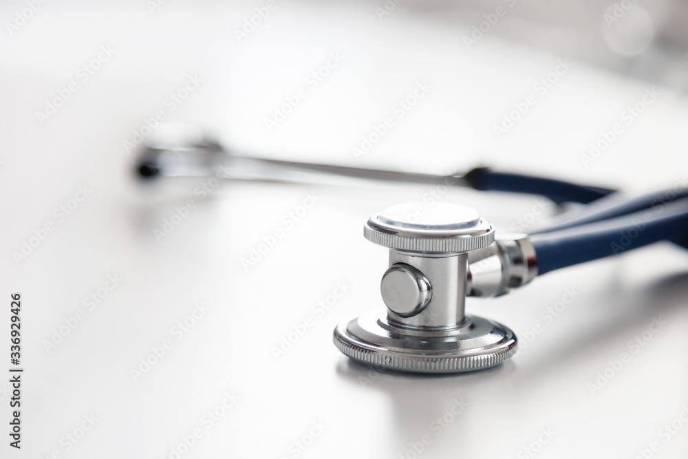 Medical stethoscope or phonendoscope on white table. Acoustic medical device for auscultation Medical stethoscope or phonendoscope on white table. Acoustic medical device for auscultation