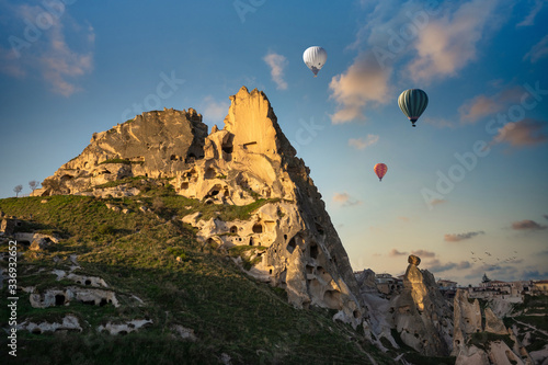 Uchisar Castle and the town is a sandstone mountain filled with tunnels and windows. In the morning, tourists come to see the balloon in Cappadocia, Turkey.