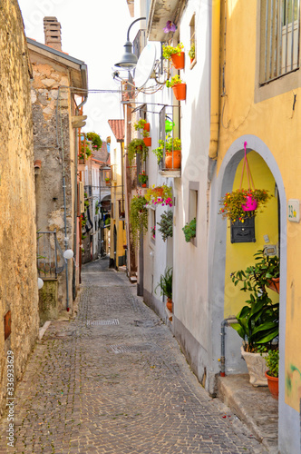 Fototapeta Naklejka Na Ścianę i Meble -  A narrow street between the colorful houses of Capriati al Volturno, a village in the province of Caserta, Italy