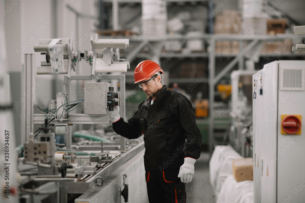 Portrait of worker in factory. Young handsome man working in factory. Portrait of worker in factory. Young handsome man working in factory.