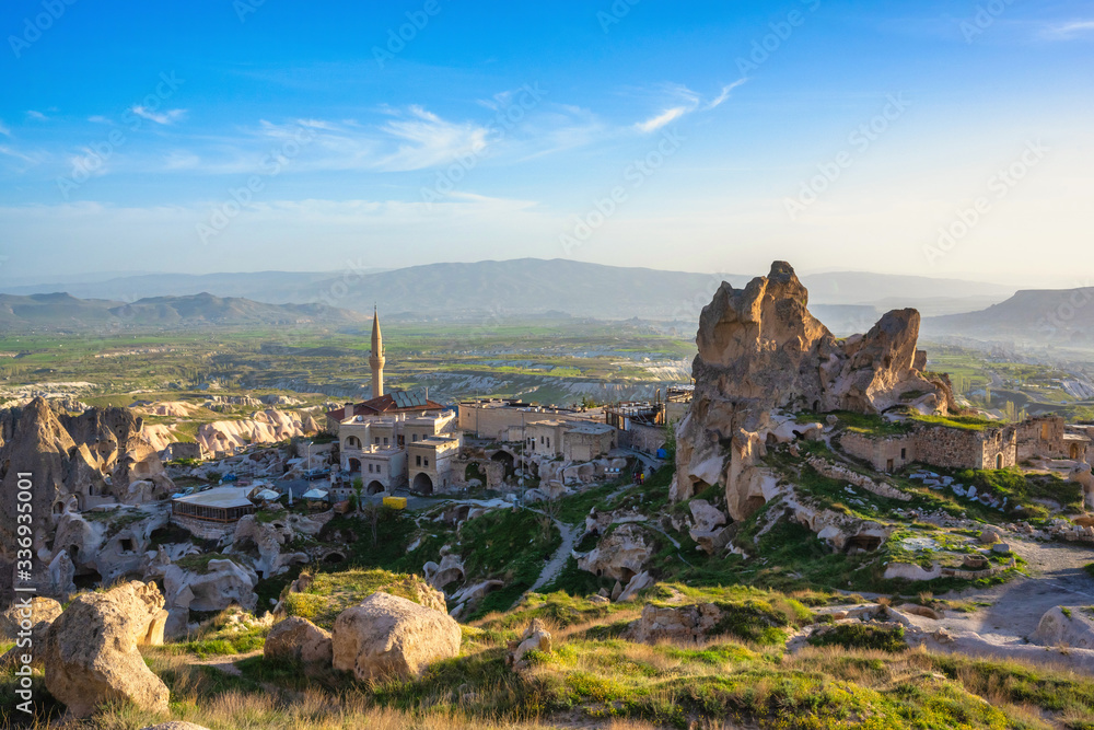 The landscape of cappadocia, Turkey. The view from the top of the hill overlooks the Uchisar Castle and this old town is a sandstone mountain. In summer, there are green grass and blue skies.