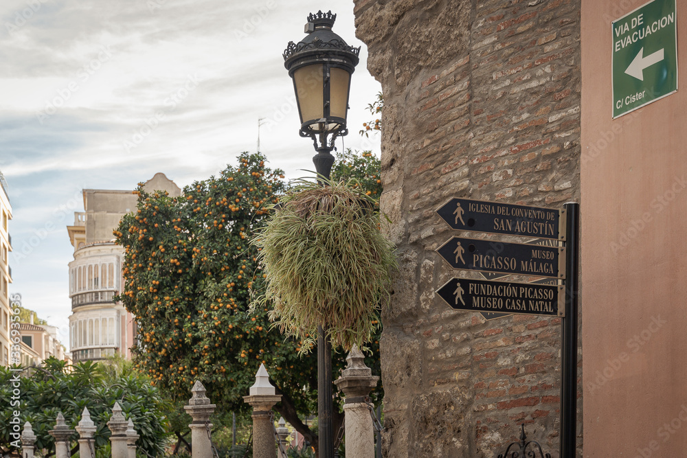 Malaga street signs directions and lamp. Stock Photo Adobe Stock