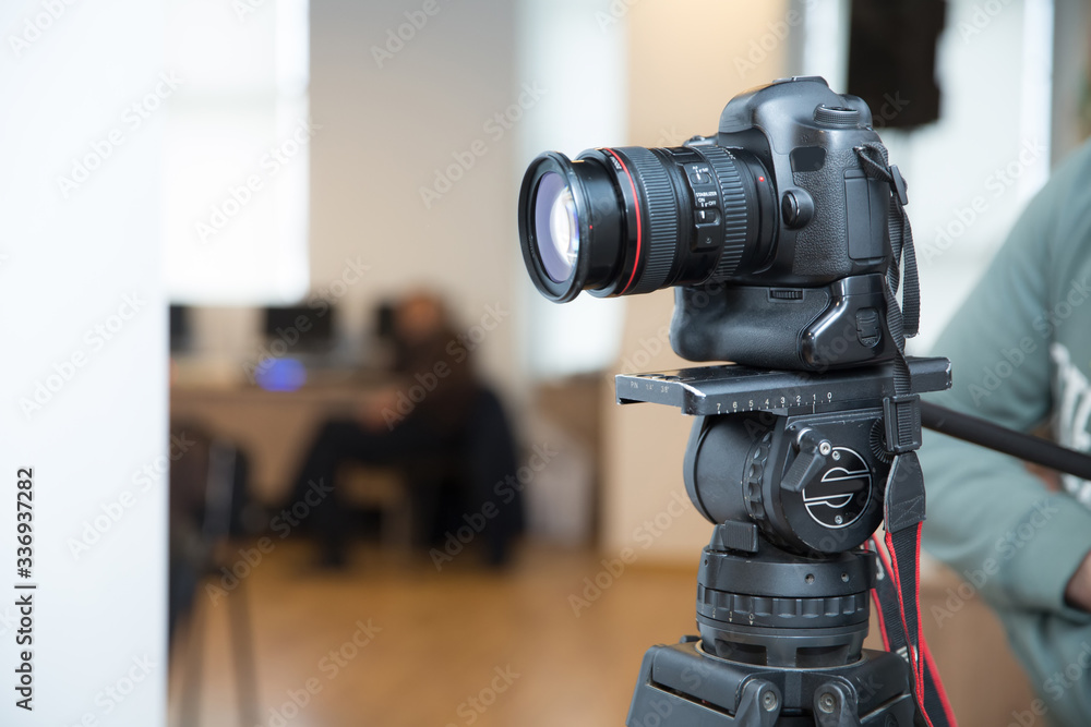 Focus on tripod mounted camera screen showing . Photo camera set on a tripod with excellent clipping path . Professional production photo camera. Camera to recording video live streaming at home .