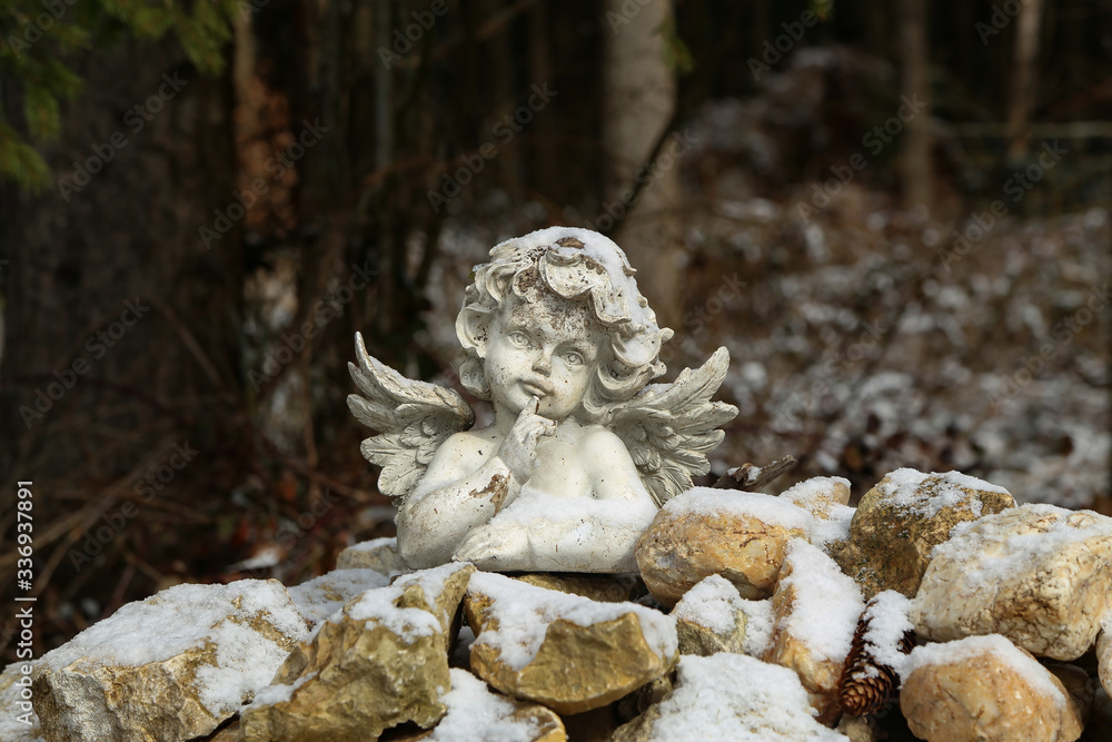 figurine: white angel on stones in the forest