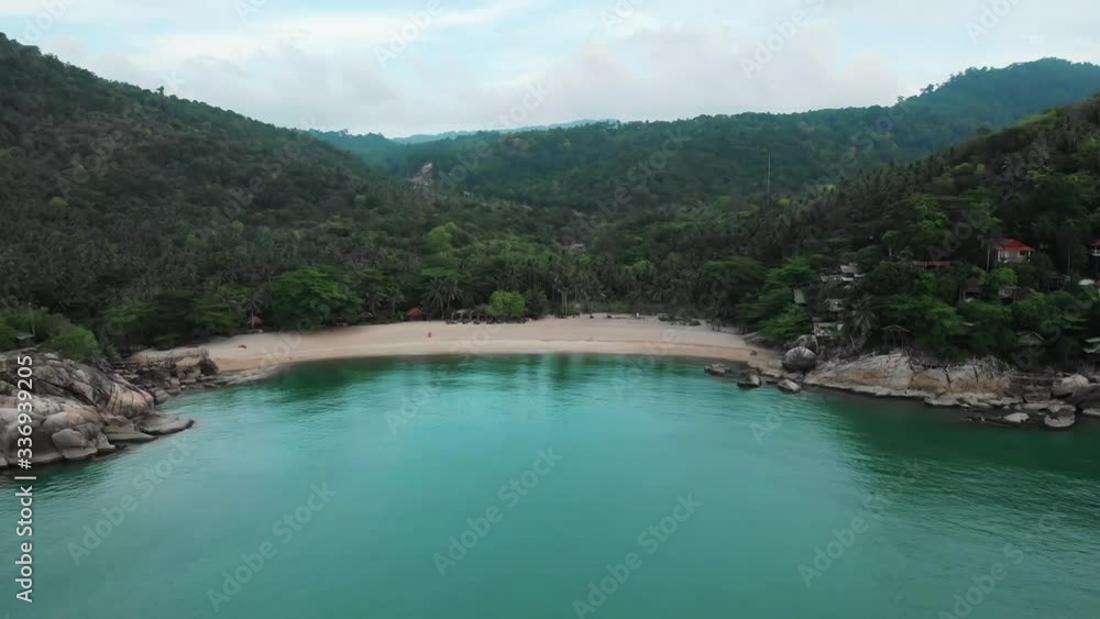 Aerial view of scenery beach. Travel to wild jungles of Thailand. Sea waves leak white sand. Palm trees pass below the drone Aerial view of scenery beach. Travel to wild jungles of Thailand. Sea waves leak white sand. Palm trees pass below the drone