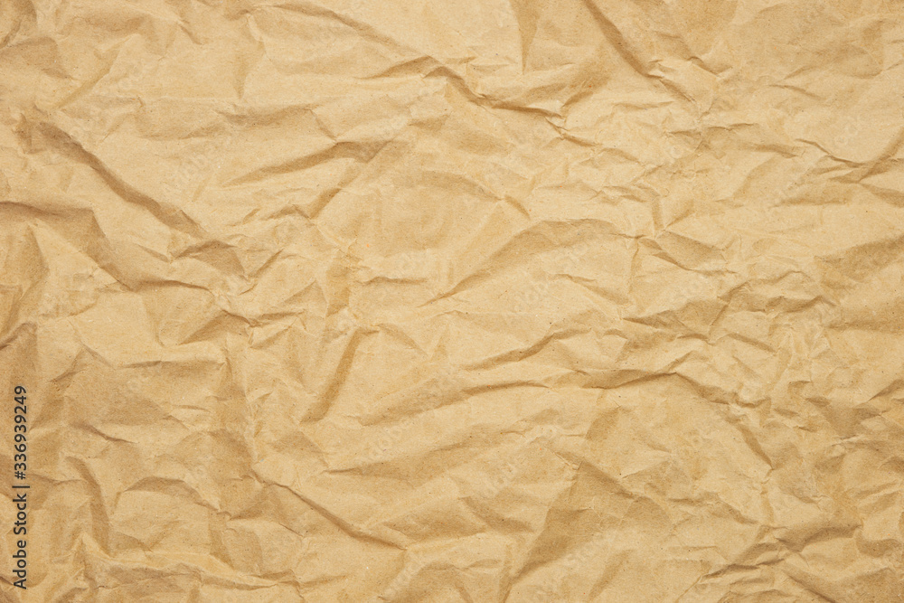 Wrinkled brown paper background. Kraft paper texture for wrapping. Eco-friendly packaging concept. Wrinkled brown paper background. Kraft paper texture for wrapping. Eco-friendly packaging concept.