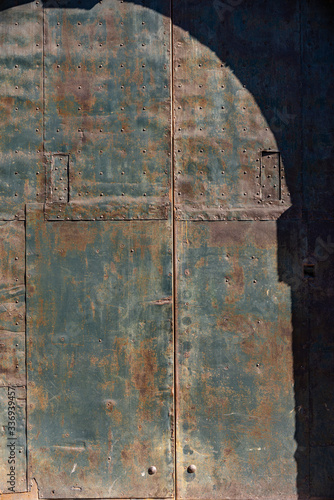 Closeup of an ancient wrought iron door with studs and rust. Full frame, background. Trento, Trentino Alto Adige, Italy, Europe