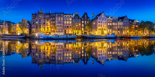 Obraz na płótnie Cityscape of Amsterdam at night with reflection of buildings on water w salonie