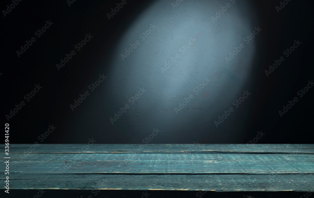 Old wood table with blurred concrete block wall in dark room background. Old wood table with blurred concrete block wall in dark room background.
