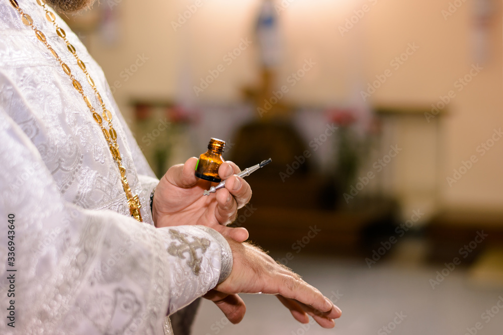 Ταπετσαρία priest hands on the anointing at baptism ceremony in orthodox church