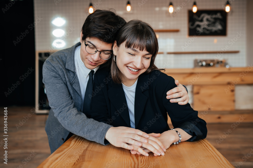 Young couple posing on camera indoors. Beautiful model girl in dress. Man in suit. Young couple posing on camera indoors. Beautiful model girl in dress. Man in suit.