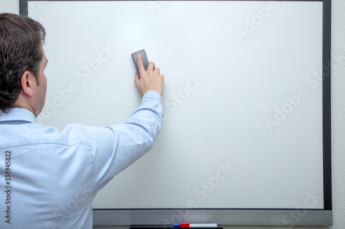 Adult man erasing on white board
