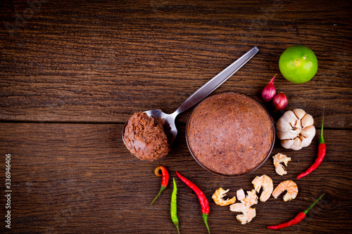 top view of  Shrimp Paste ( kapi ) and thai ingredient  in glass bowl on wooden background.
