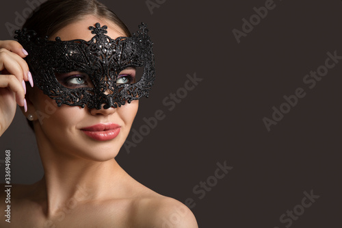 women in a black carnival mask. Portrait on a dark background