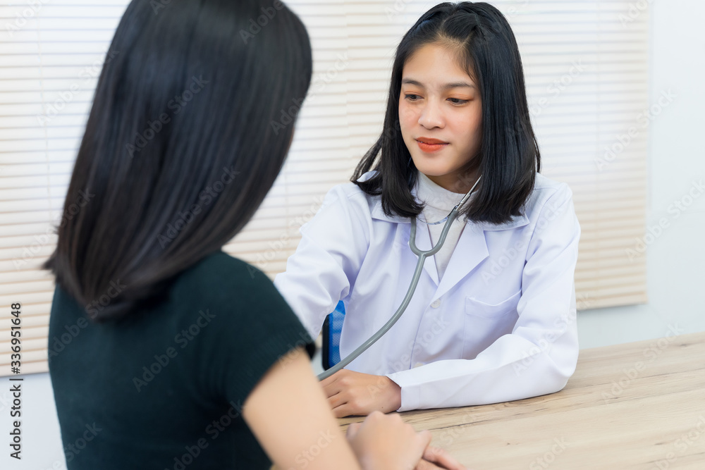 Young Asian female doctor uses the stethoscope to examine and diagnose adult female patient’s sickness and symptom. Medicine and health care concept. Doctor and patient. Young Asian female doctor uses the stethoscope to examine and diagnose adult female patient’s sickness and symptom. Medicine and health care concept. Doctor and patient.