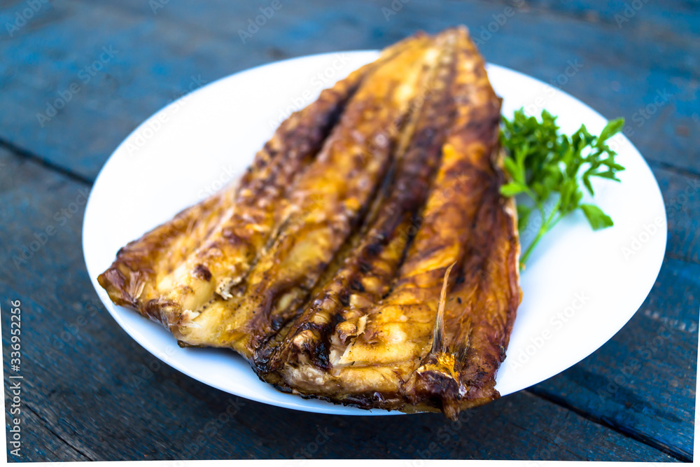 Baked mackerel fish on a white plate