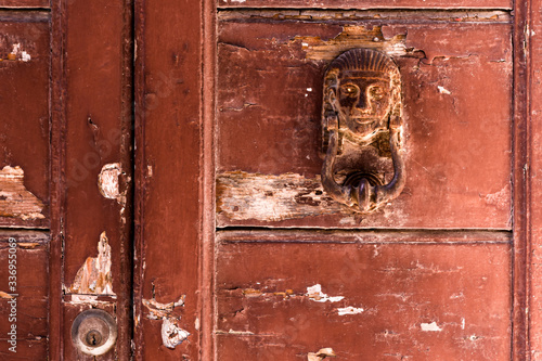 Obraz na płótnie Detail of an old, weathered and rustic door with a rusty, Egyptian themed door knocker w salonie