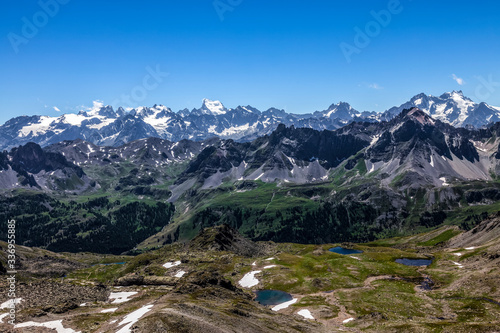 High altitude landscape in Alps with the view of Barre des Ecrins and La Meije in the distance. 