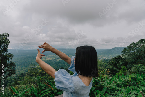 young cute Japanese Asian hipster girl travelling at beautiful sky 
mountains scenery park hiking garden views at Kanchanaburi Thailand guiding idea for female backpacker woman women backpacking