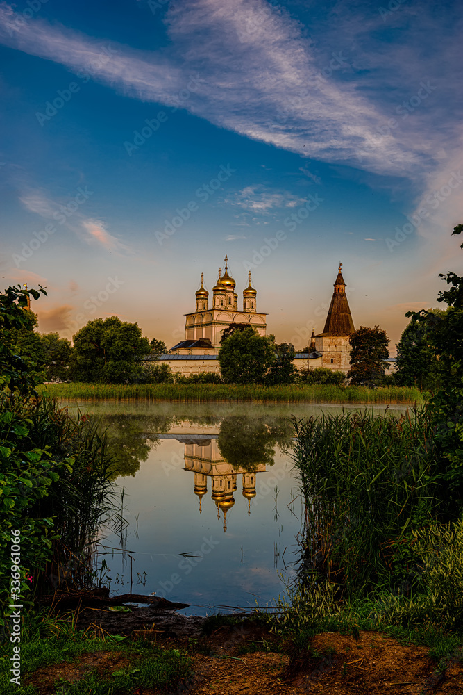 Sunrise over the Cathedral of the Joseph-Volotsky Monastery. The cloister is located in the village of Morning calm over the lake next to the Joseph-Volotsky Monastery. Teryaevo.