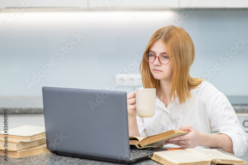 Girl is doing homework with laptop at home. Distance learning