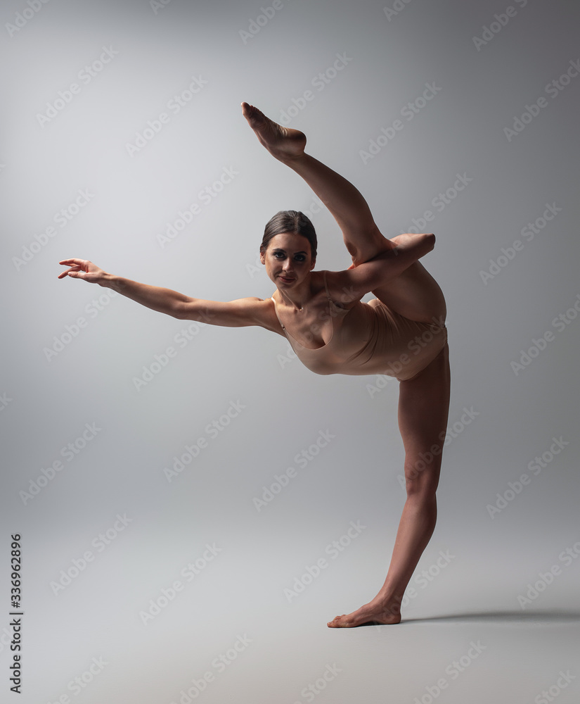 Fototapeta premium Young Flexible gymnast woman stretching and posing in studio.