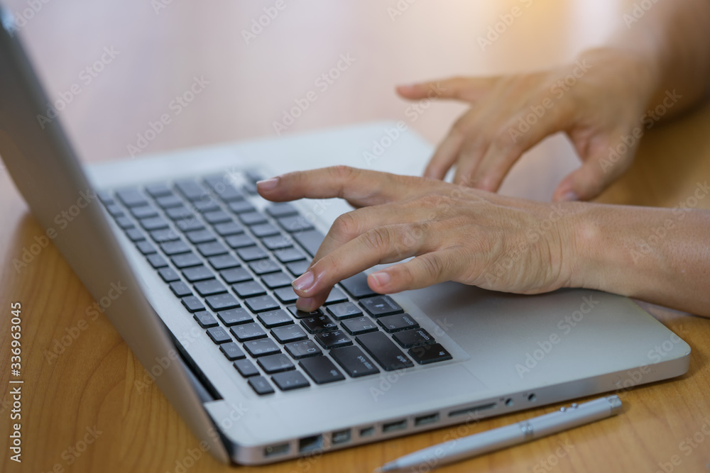 Cropped shot of a woman using a laptop while working from home Cropped shot of a woman using a laptop while working from home