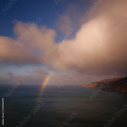 Epic view of Atlantic ocean cliffs under heavy clouds with rainbow, Slieve League, Donegal, Ireland