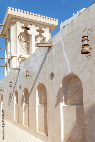 Wall of the building at the traditional market with lamps casting interesting shadows. UAE heritage.