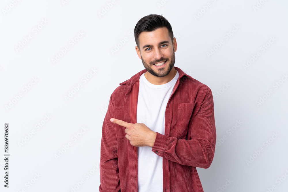 Young handsome man with beard wearing a corduroy jacket over isolated white background pointing to the side to present a product Young handsome man with beard wearing a corduroy jacket over isolated white background pointing to the side to present a product