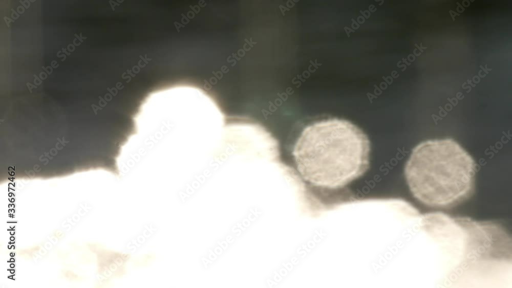 Bokeh sun glare reflected in water surface. Abstract flickering background. Bokeh sun glare reflected in water surface. Abstract flickering background.