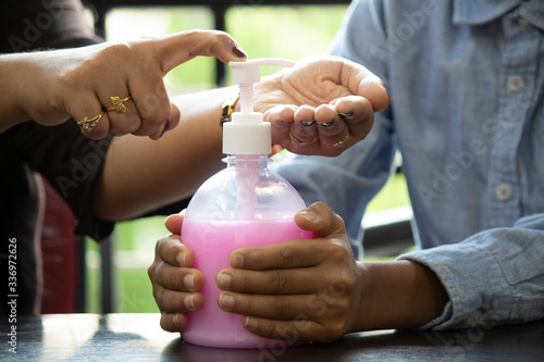 Mother teaching son how to clean hands with sanitizer