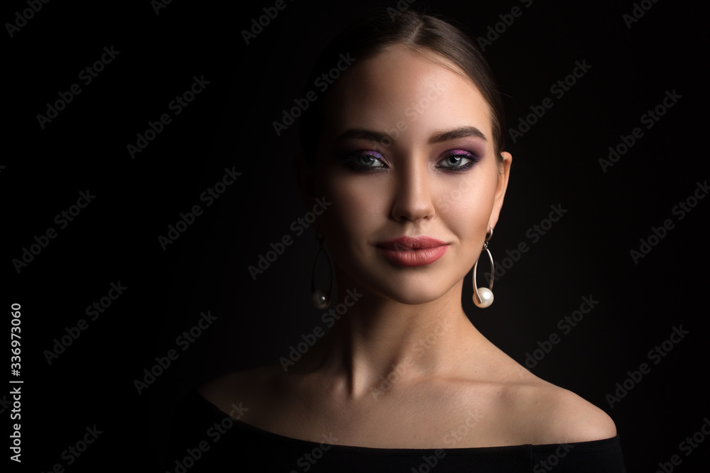 Fototapeta premium portrait of a beautiful young woman on a black background. Copycpase