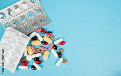 Various medications, tablets, and vitamins. Blue background, place to insert text. Health and pharmacy.