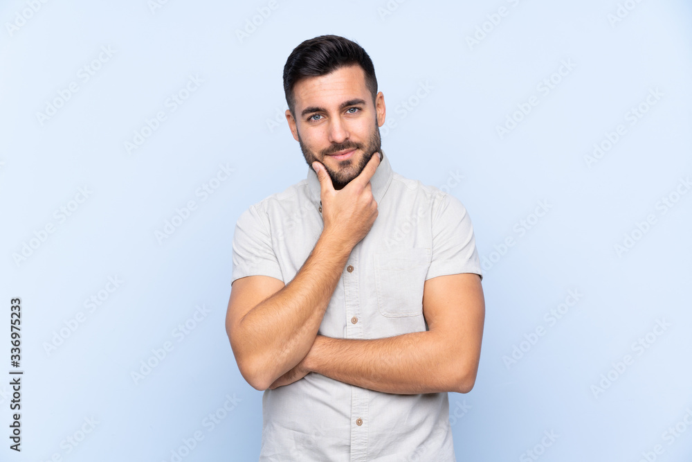 Young handsome man with beard over isolated blue background thinking an idea Young handsome man with beard over isolated blue background thinking an idea