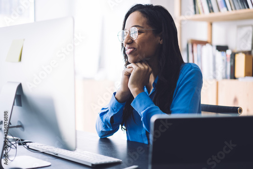 Smiling woman watching webinar on computer photo