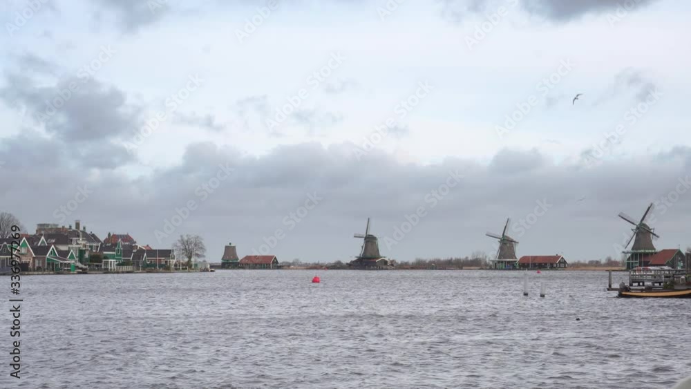 Wide shot of the canal and the windmills, in Zaanse Schans, in the Netherlands. Wide shot of the canal and the windmills, in Zaanse Schans, in the Netherlands.