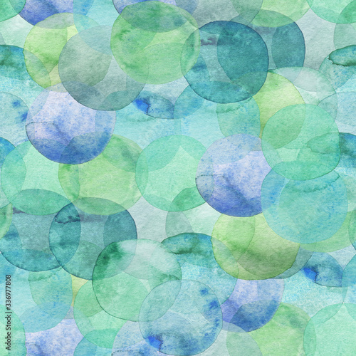 Seamless pattern of green and blue translucent watercolor circles. Hand painted Spots on a white background. Round. Isolated. Blobs of different colors