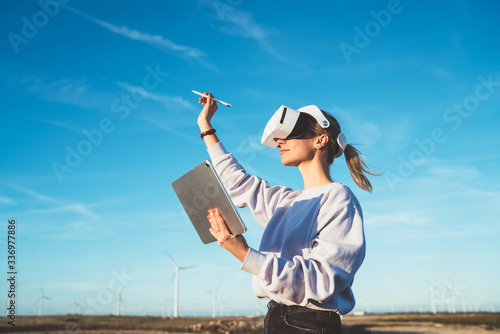 Woman having VR experience in wind farm photo