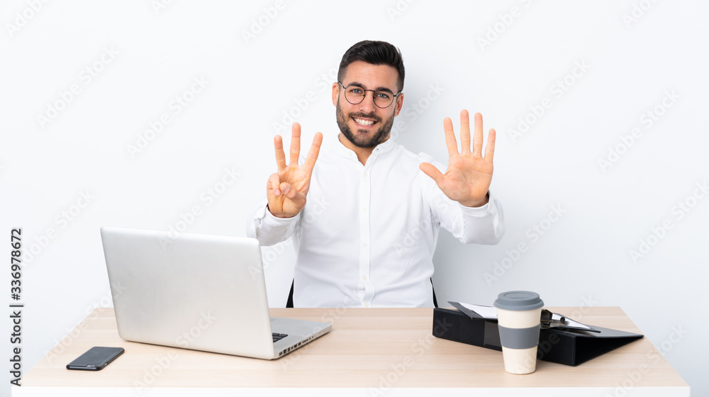Young businessman in a workplace counting eight with fingers Young businessman in a workplace counting eight with fingers