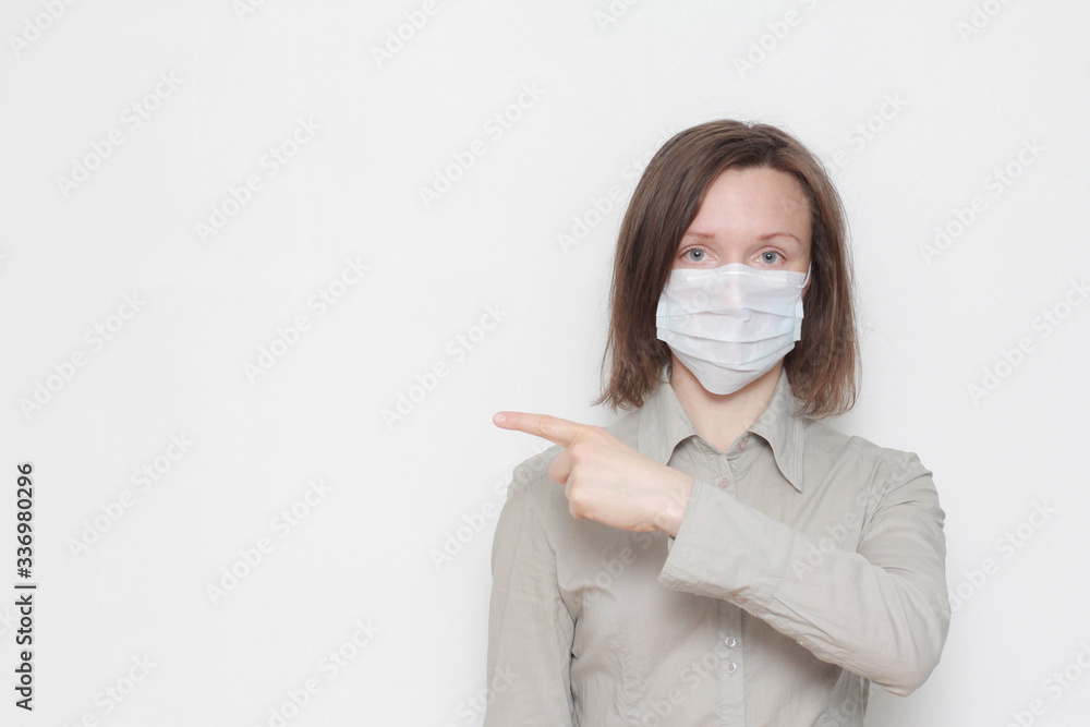 Woman wearing protective mask pointing finger at copy space isolated over white background. Coronavirus, pandemic, safety, protection, epidemic prevention Woman wearing protective mask pointing finger at copy space isolated over white background. Coronavirus, pandemic, safety, protection, epidemic prevention