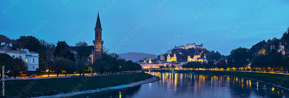 Naklejka premium Salzburg city evening panorama. Cathedral, Old Town Altstadt, Evangelische Pfarrgemeinde Christuskirche Hohensalzburg castle illuminated at night. Salzach River waterfront promenade. Salzburg, Austria