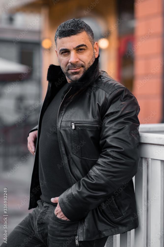 a man in a leather jacket on the background of the metropolis. eastern appearance of the model. a man in a leather jacket on the background of the metropolis. eastern appearance of the model.