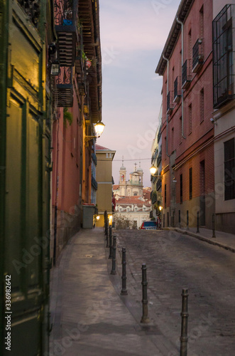 View of a lonely street surrounded by colonial-style buildings and houses as evening falls