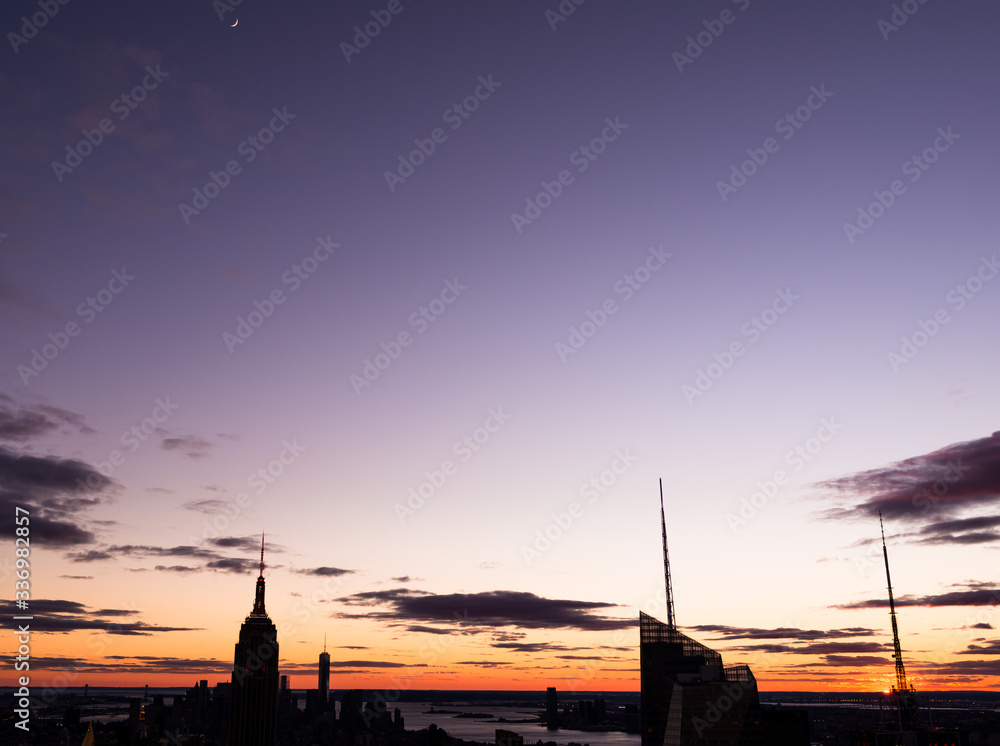 Fototapeta premium New York City silhouette at the rare moment when sun and moon are visible in the frame