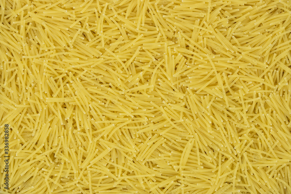 Uncooked vermicelli pasta texture background. Traditional Italian food. Uncooked vermicelli pasta texture background. Traditional Italian food.