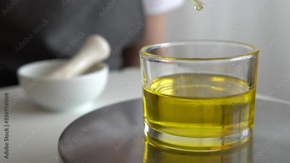 Making natural cosmetics product with cosmetic oil, woman mix and stir oils in mortar, aromatherapy, cosmetology. Making natural cosmetics product with cosmetic oil, woman mix and stir oils in mortar, aromatherapy, cosmetology.