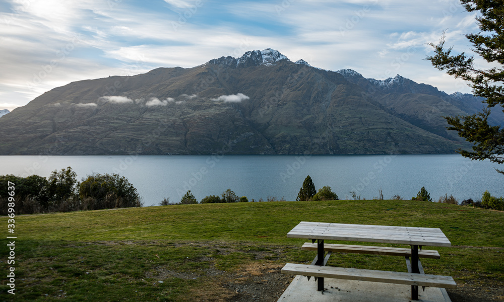 Beautiful view of a country table with Lake Wakatipu and snow capped mountains in the background taken on a winter day in Queenstown, New Zealand